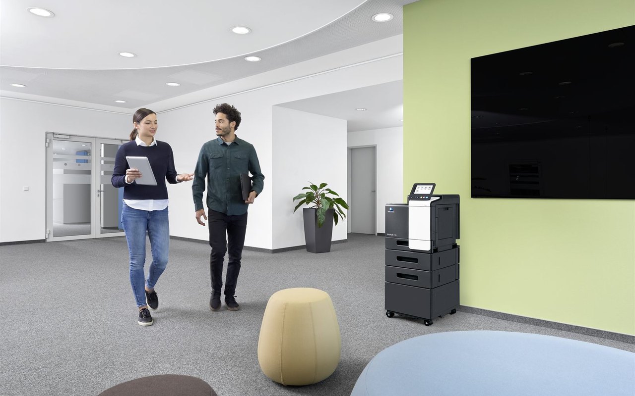 Copieur multifonction Konica Minolta en open space avec deux collaborateurs, questions frequentes